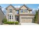 Charming two-story brick home with a well-manicured lawn and attached two-car garage at 1595 Johnstown Trace, Suwanee, GA 30024