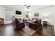 Cozy living room with a fireplace, ceiling fan, and comfortable leather seating at 1595 Johnstown Trace, Suwanee, GA 30024