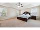 Bright main bedroom featuring a tray ceiling, carpet, and lots of natural light at 1595 Johnstown Trace, Suwanee, GA 30024