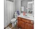 Bathroom with a vanity, mirror, toilet and shower with striped curtain at 310 Persimmon Dr, Sharpsburg, GA 30277