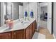 Bathroom featuring double sinks with wood cabinets and a large mirror at 310 Persimmon Dr, Sharpsburg, GA 30277