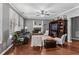Comfortable living room featuring a fireplace, ceiling fan, and hardwood floors at 310 Persimmon Dr, Sharpsburg, GA 30277