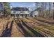 View of home's rear exterior and large backyard, with a covered patio at 310 Persimmon Dr, Sharpsburg, GA 30277