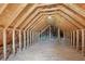 Unfinished attic with exposed wooden beams and plywood flooring at 3100 Plantation Run Dr, Loganville, GA 30052