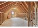 Unfinished attic with wooden beams and a window at 3100 Plantation Run Dr, Loganville, GA 30052