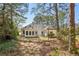 View of the backyard with patio, sunroom and swing with mature trees providing shade at 3100 Plantation Run Dr, Loganville, GA 30052