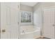 Bathroom featuring a soaking tub and a bright window at 3100 Plantation Run Dr, Loganville, GA 30052