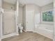 Bathroom featuring a glass shower, toilet, and tub with a window at 3100 Plantation Run Dr, Loganville, GA 30052