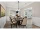 Elegant dining area with wainscoting, modern chandelier, and access to the living room and sunroom at 3100 Plantation Run Dr, Loganville, GA 30052