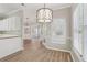 Dining room view featuring light wood-look floors, neutral walls, and modern lighting fixture at 3100 Plantation Run Dr, Loganville, GA 30052