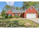 Charming brick home with a well-manicured lawn and mature landscaping at 3100 Plantation Run Dr, Loganville, GA 30052