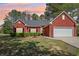 Charming brick home with a well-manicured lawn and mature landscaping at 3100 Plantation Run Dr, Loganville, GA 30052