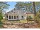 Backyard shot of home with covered porch swing and mature trees providing shade at 3100 Plantation Run Dr, Loganville, GA 30052