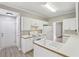 Bright kitchen with white cabinets, white appliances, neutral walls, and light wood-look floors at 3100 Plantation Run Dr, Loganville, GA 30052