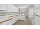 Bright kitchen featuring white appliances, white cabinets, and light wood-look floors at 3100 Plantation Run Dr, Loganville, GA 30052