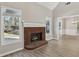 Living room featuring a brick fireplace, neutral walls, light wood-look floors, and bright windows at 3100 Plantation Run Dr, Loganville, GA 30052