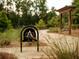 Scenic community area with walking trails, lush greenery, and a relaxing pergola swing at 7220 Summit Pl, Alpharetta, GA 30009