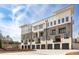 Corner exterior view of modern townhomes with attached garages and balcony at 7220 Summit Pl, Alpharetta, GA 30009