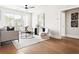 Well-lit living room showcasing a modern aesthetic, hardwood floors, and access to other rooms at 7220 Summit Pl, Alpharetta, GA 30009