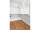Spacious walk-in closet with custom shelving and hardwood floors, providing ample storage at 7220 Summit Pl, Alpharetta, GA 30009