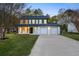 Renovated two-story house features a spacious front lawn with a large driveway leading to a two-car garage at 10540 Willow View Cir, Alpharetta, GA 30022