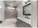 Bathroom featuring gray vanity with marble top and a shower-tub combo with marble-style tile surround at 2562 Tritt Springs Ne Trce, Marietta, GA 30062