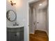 Bathroom showcasing a corner vanity with light gray cabinets and a round mirror at 2562 Tritt Springs Ne Trce, Marietta, GA 30062