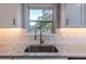 Close-up of kitchen sink featuring granite countertops, stylish backsplash, and modern faucet at 2562 Tritt Springs Ne Trce, Marietta, GA 30062