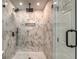 This walk-in shower features dual shower heads, marble-look tiling, and recessed shelving at 2562 Tritt Springs Ne Trce, Marietta, GA 30062