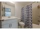 Modern bathroom features white vanity, toilet, tub/shower combo with a geometric shower curtain at 4565 Sims Park Overlook, Suwanee, GA 30024
