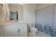 Clean bathroom with white vanity, mirror, toilet, and a blue patterned shower curtain over a tub at 4565 Sims Park Overlook, Suwanee, GA 30024