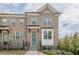 Beautiful brick exterior of a two-story townhome with a blue front door and manicured landscaping at 4565 Sims Park Overlook, Suwanee, GA 30024