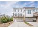 Exterior view of townhomes shows white siding, wooden decks, garages, and landscaping at 4565 Sims Park Overlook, Suwanee, GA 30024