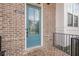 Close-up of a blue front door with glass panel, brick facade and black railing at 4565 Sims Park Overlook, Suwanee, GA 30024