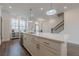 Bright kitchen featuring a large island with bar seating, stainless steel dishwasher, and pendant lights at 4565 Sims Park Overlook, Suwanee, GA 30024