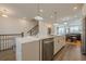 Spacious kitchen with a large island, modern lighting, stainless steel appliances and bar stool seating at 4565 Sims Park Overlook, Suwanee, GA 30024