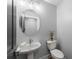Well-lit half bathroom featuring an oval mirror, sink, and toilet at 99 Brown Ave, Atlanta, GA 30315