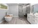 Bathroom with a glass walk-in shower, a freestanding tub, and a vanity with drawers at 99 Brown Ave, Atlanta, GA 30315
