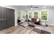 Cozy living room with large windows, modern ceiling fan, and a brown leather sofa at 99 Brown Ave, Atlanta, GA 30315