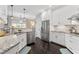 Well-lit kitchen featuring stainless steel appliances, granite countertops, and sleek white cabinetry at 111 Franklin Rd, Woodstock, GA 30188