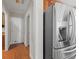 Hallway view featuring a stainless steel refrigerator and hardwood floors leading to a white door at 3855 Cohutta Pass, Marietta, GA 30062