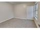 Cozy bedroom featuring neutral carpet, a double-door closet, and a bright window at 1809 Fairpointe Trce, Stone Mountain, GA 30088