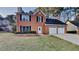 Charming two-story brick home featuring a well-manicured lawn and a two-car garage at 1809 Fairpointe Trce, Stone Mountain, GA 30088