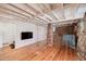 Rustic basement featuring exposed brick and stone, wooden floors, bar area, and a TV at 2795 Kimmeridge Dr, Atlanta, GA 30344