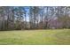 A fully grassed backyard featuring partial fencing and mature trees in the background at 3061 Stone Bridge Sw Trl, Conyers, GA 30094