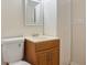 This bathroom has wood-look flooring, a wooden vanity, and a white storage cabinet at 3061 Stone Bridge Sw Trl, Conyers, GA 30094