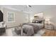 This bedroom boasts natural light, tray ceilings, a ceiling fan, and hardwood floors at 3061 Stone Bridge Sw Trl, Conyers, GA 30094