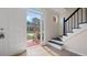 Bright foyer with wood floors, staircase with black iron railing, and view of front yard at 3061 Stone Bridge Sw Trl, Conyers, GA 30094