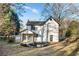 Charming two-story home featuring a cozy front porch and a stone fire pit in the landscaped yard at 6382 Revena Dr, Morrow, GA 30260