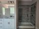 Bathroom featuring granite counters, double vanity, framed mirrors, and a tiled shower at 6841 Phillips Mill Rd, Douglasville, GA 30135